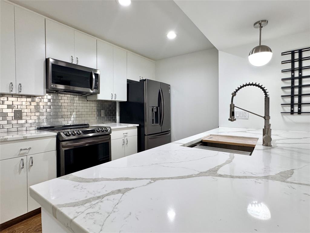 4134 Travis Street, Unit 2 Dallas, TX 75204 - Photo 3 of 28 a kitchen with kitchen island a sink stainless steel appliances and cabinets