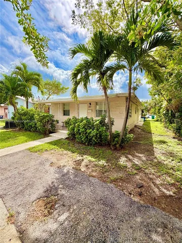 a view of a house with a big yard and large trees