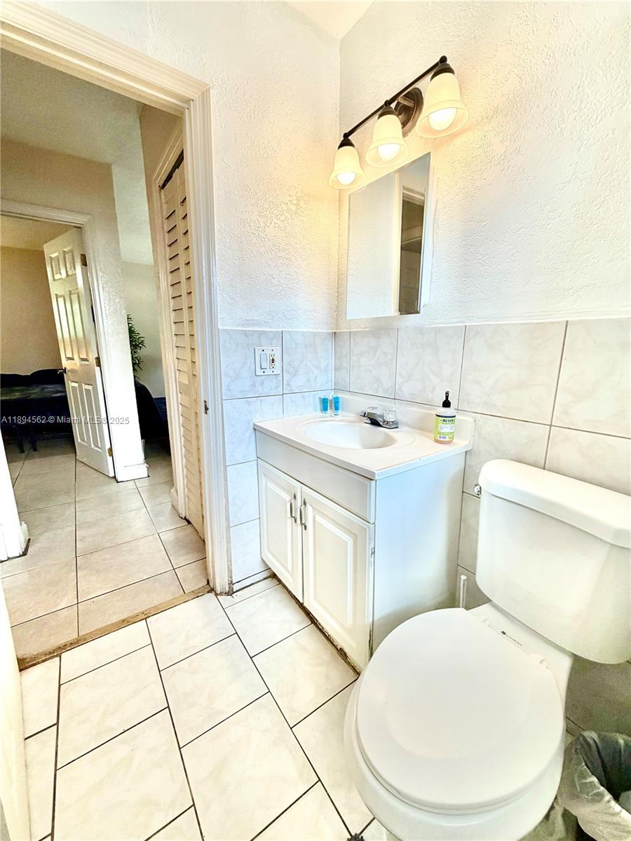211 Stirling Road, Unit 1 Dania Beach, FL 33004 - Photo 14 of 21 a bathroom with a sink a toilet and mirror