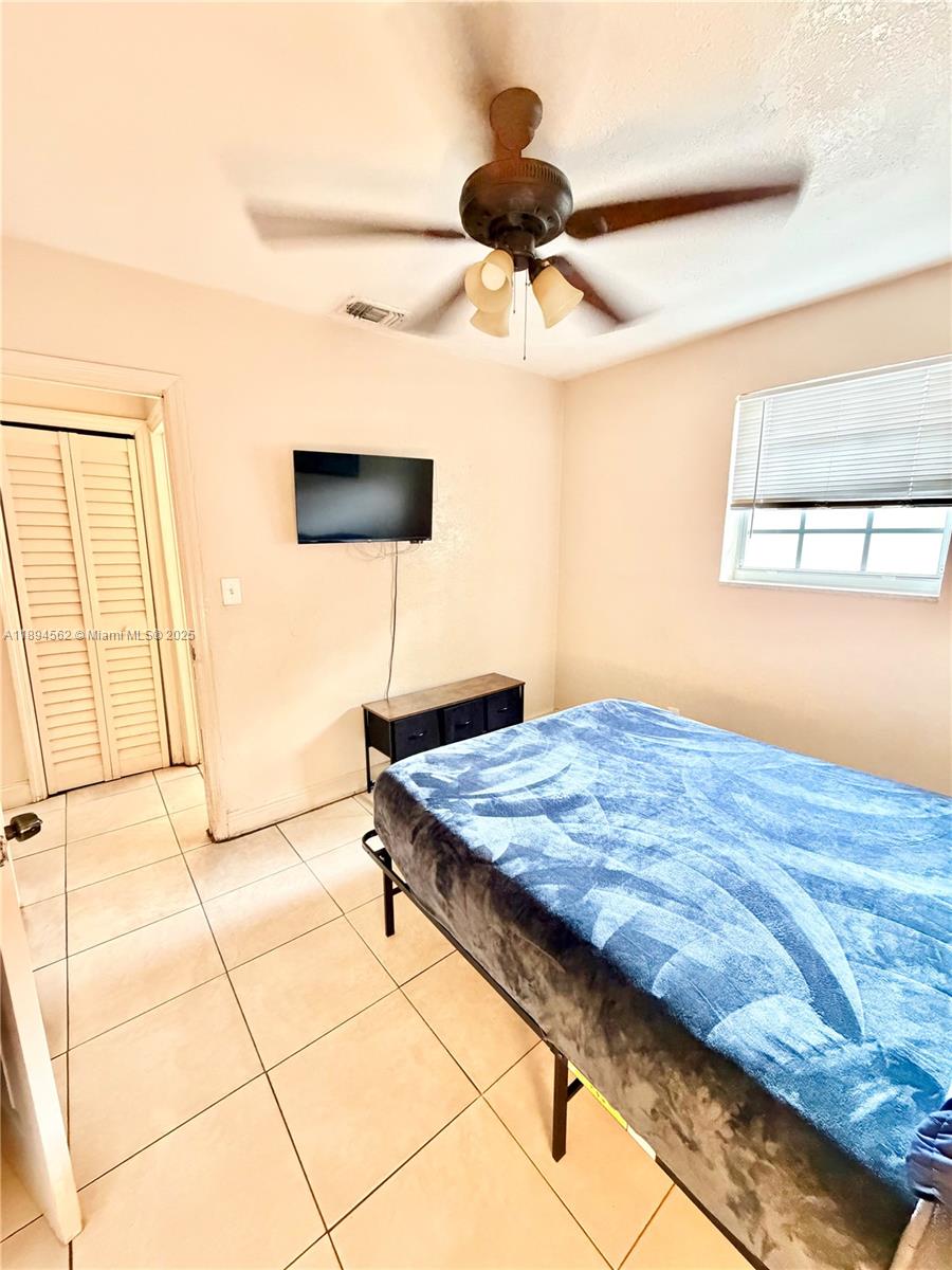 211 Stirling Road, Unit 1 Dania Beach, FL 33004 - Photo 15 of 21 a bedroom with a bed and a ceiling fan