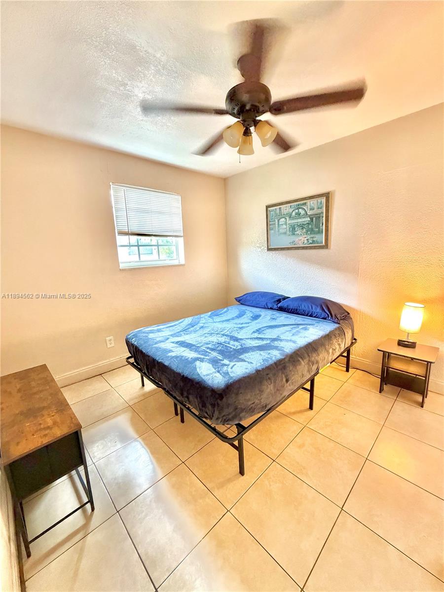 211 Stirling Road, Unit 1 Dania Beach, FL 33004 - Photo 16 of 21 a bedroom with a bed and a painting on the wall
