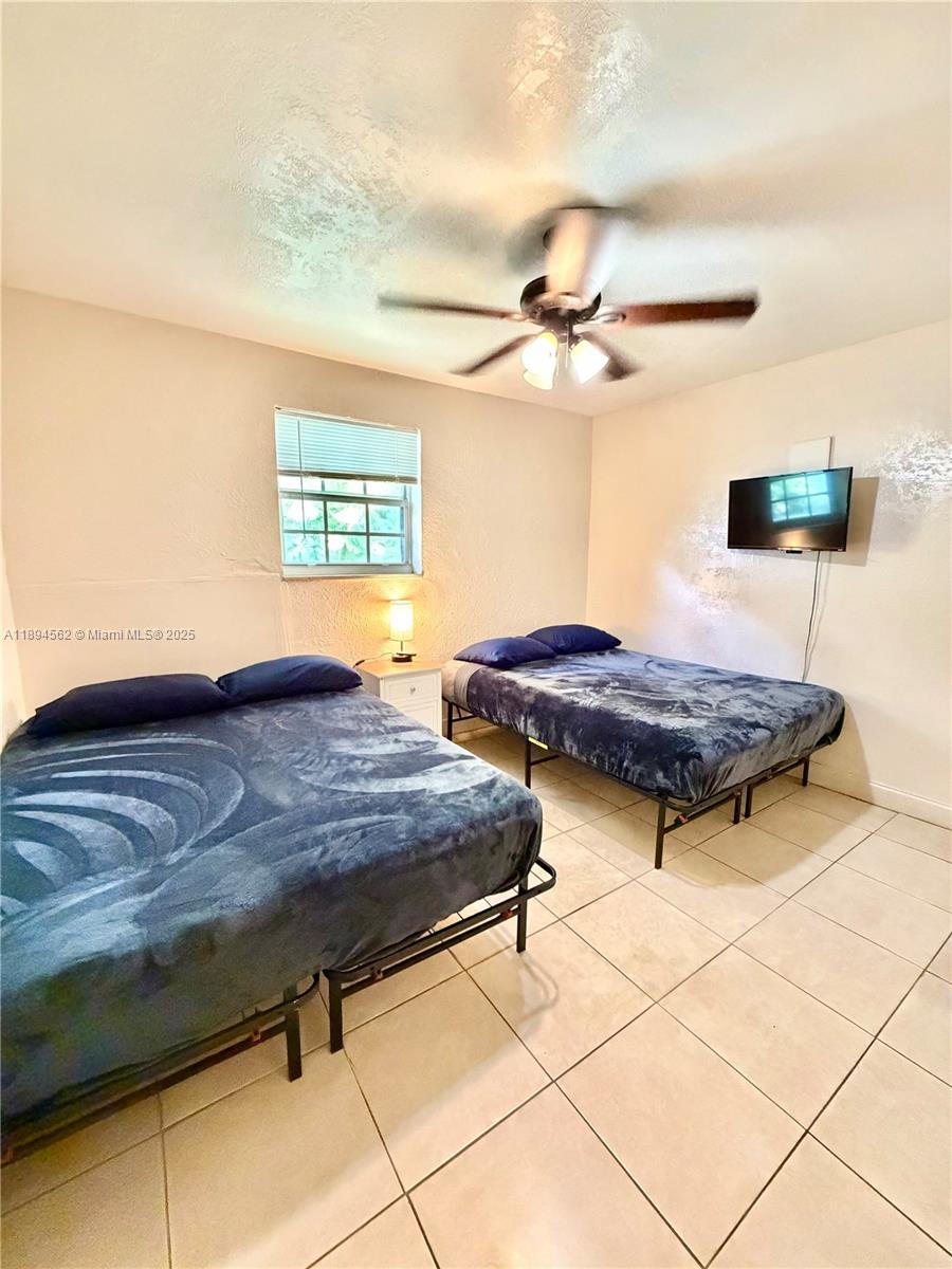 211 Stirling Road, Unit 1 Dania Beach, FL 33004 - Photo 19 of 21 a bedroom with two beds and a ceiling fan