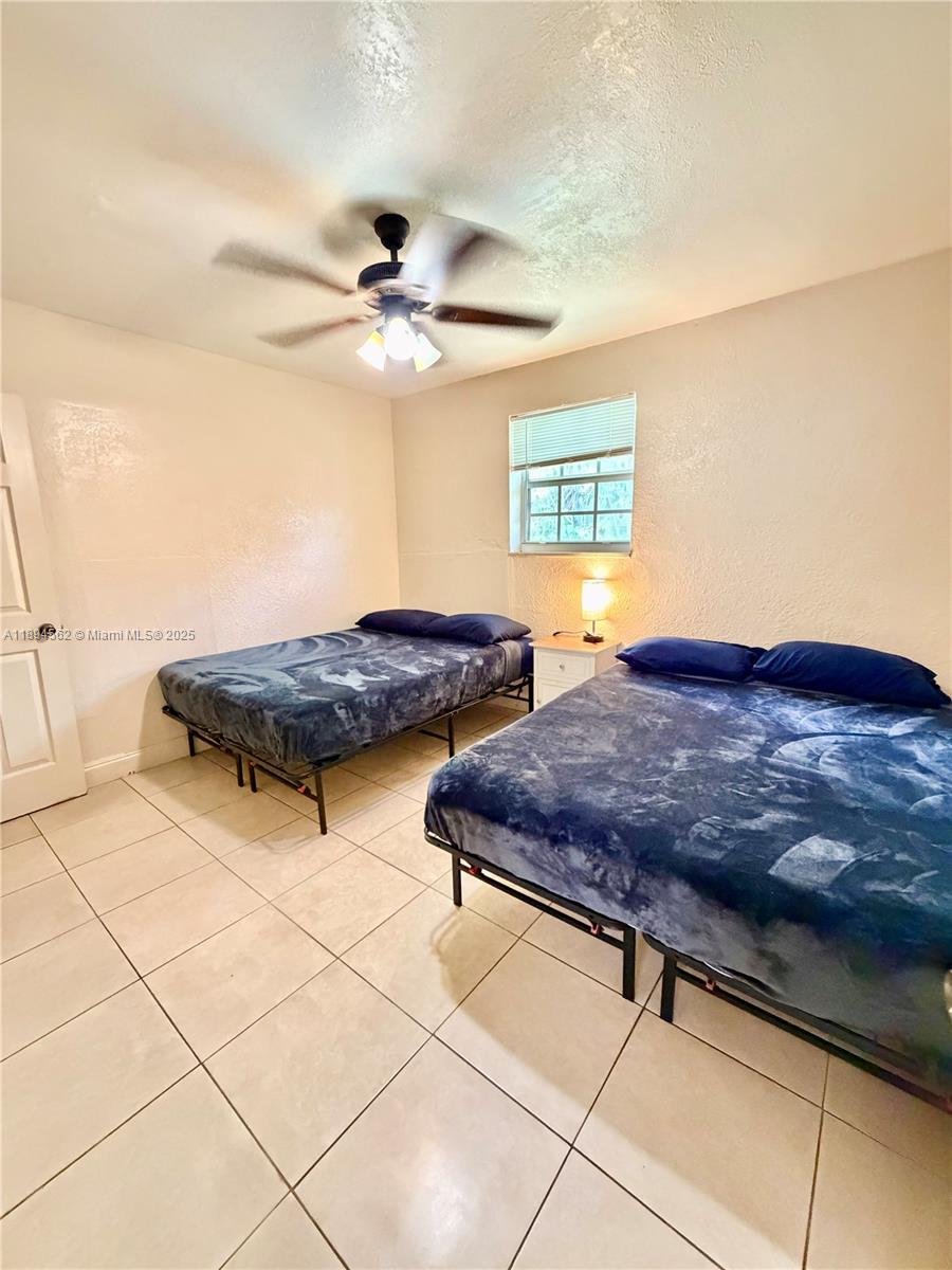 211 Stirling Road, Unit 1 Dania Beach, FL 33004 - Photo 20 of 21 a bedroom with two beds and a ceiling fan