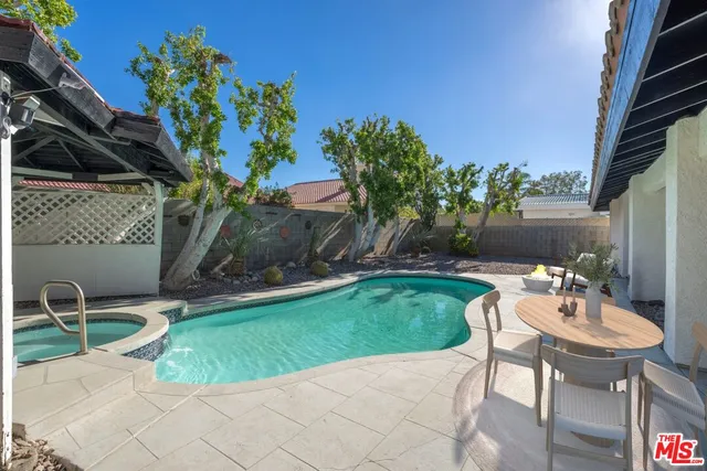 a view of a chairs and table in backyard