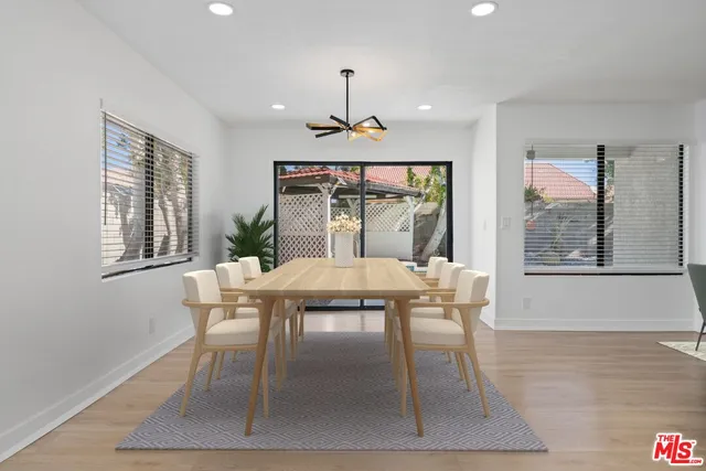 a dining room with furniture a chandelier and wooden floor