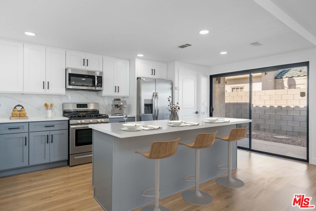 67350 Medano Road Cathedral City, CA 92234 - Photo 5 of 20 a kitchen with stainless steel appliances granite countertop a stove a sink a refrigerator and a cabinets