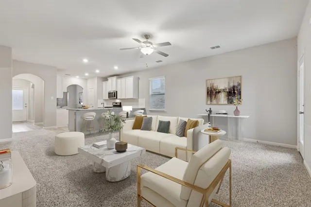 a living room with furniture kitchen view and a chandelier
