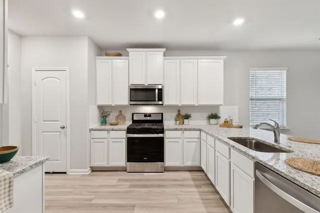 a kitchen with appliances a sink and cabinets