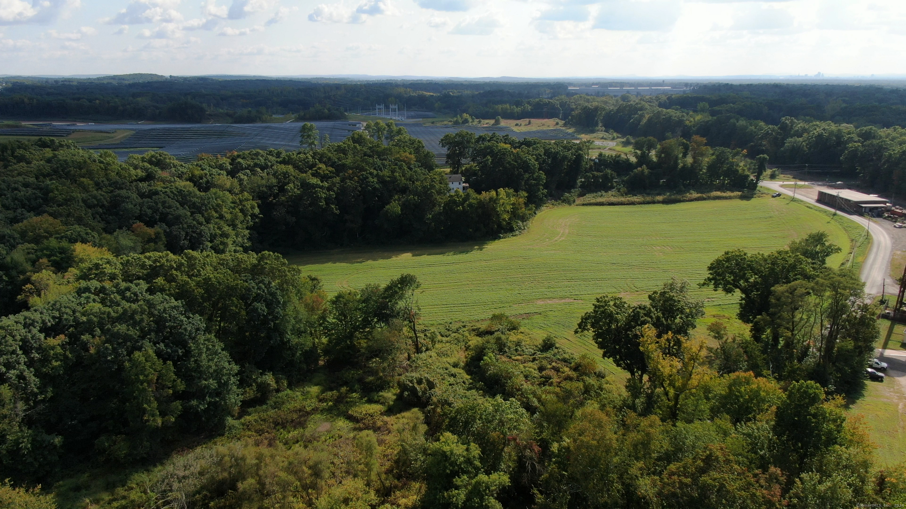 0 Chamberlain Road Broad Brook, CT 06016 - Photo 13 of 16 an aerial view of green landscape with trees houses and mountain view