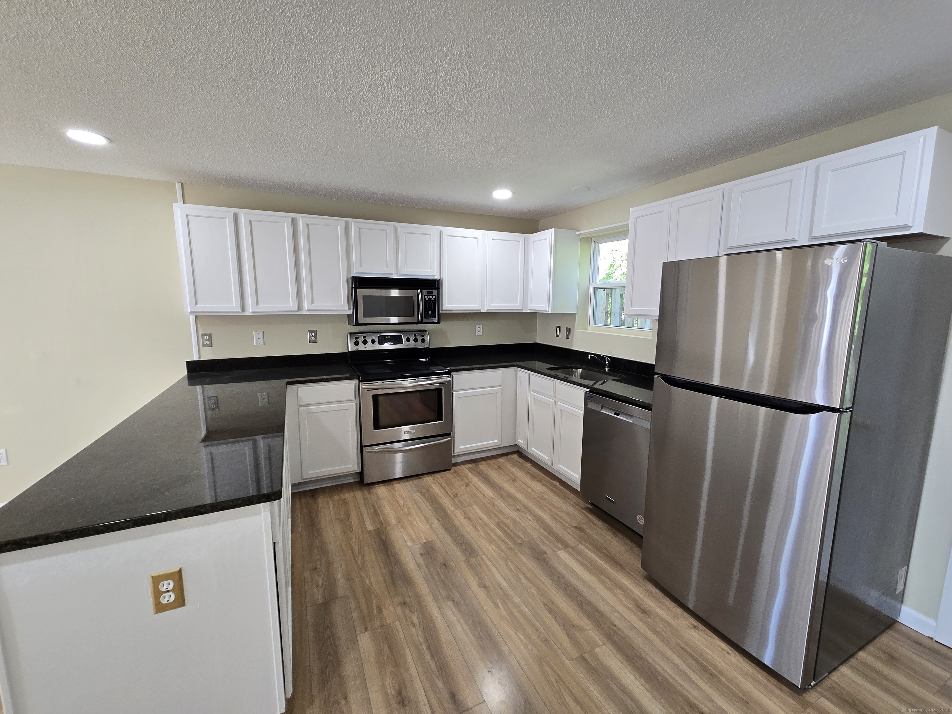 5 Periwinkle Lane, Unit 5 Glastonbury, CT 06033 - Photo 11 of 23 a kitchen with wooden cabinets and stainless steel appliances