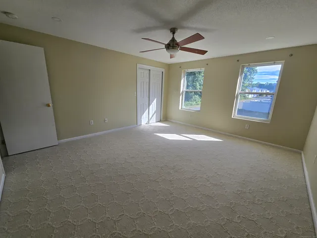 a view of a livingroom with a ceiling fan and window