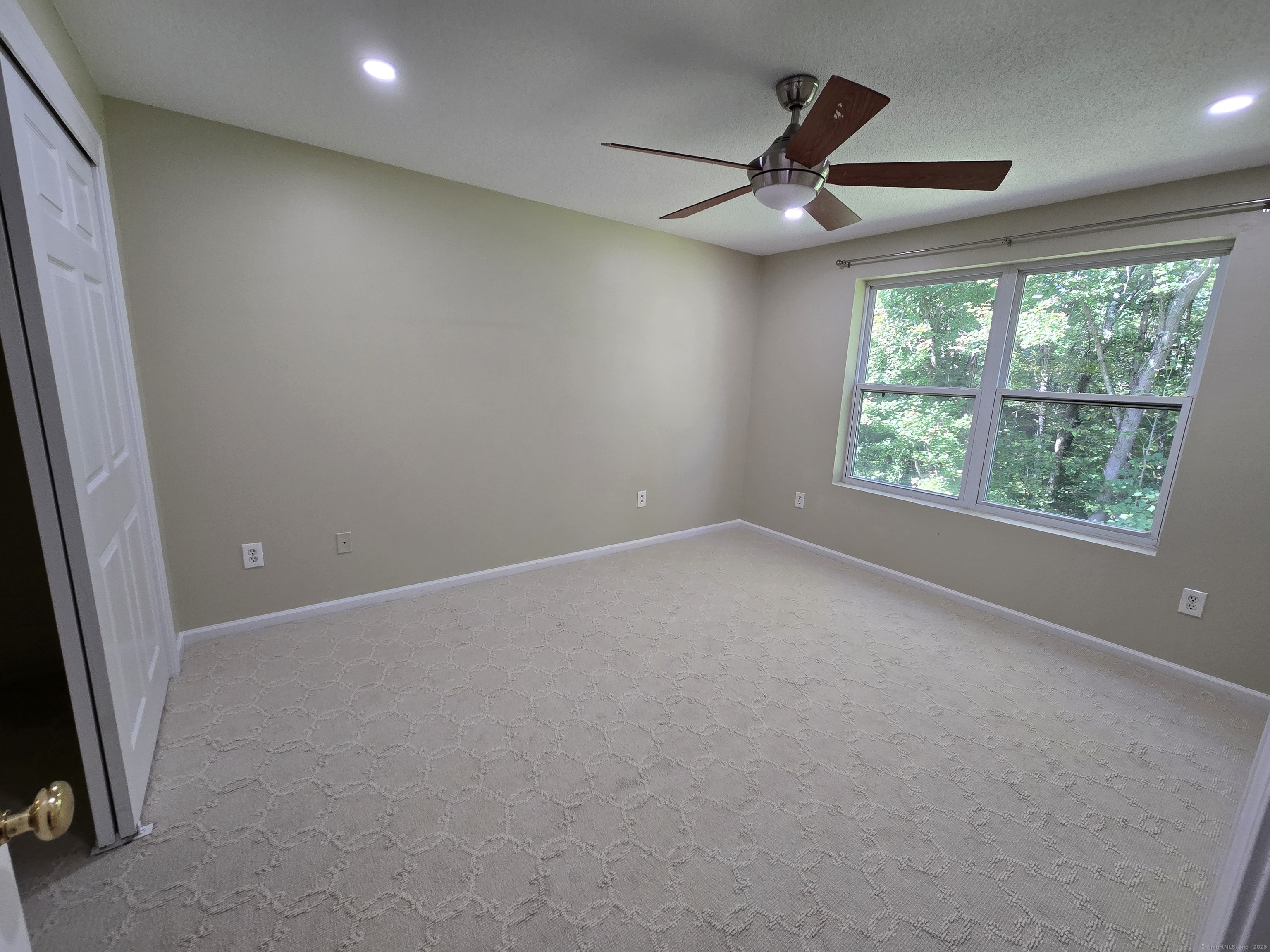 5 Periwinkle Lane, Unit 5 Glastonbury, CT 06033 - Photo 17 of 23 an empty room with a ceiling fan and window