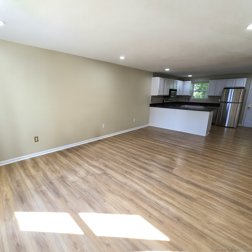 5 Periwinkle Lane, Unit 5 Glastonbury, CT 06033 - Photo 5 of 23 a view of kitchen and empty room with wooden floor