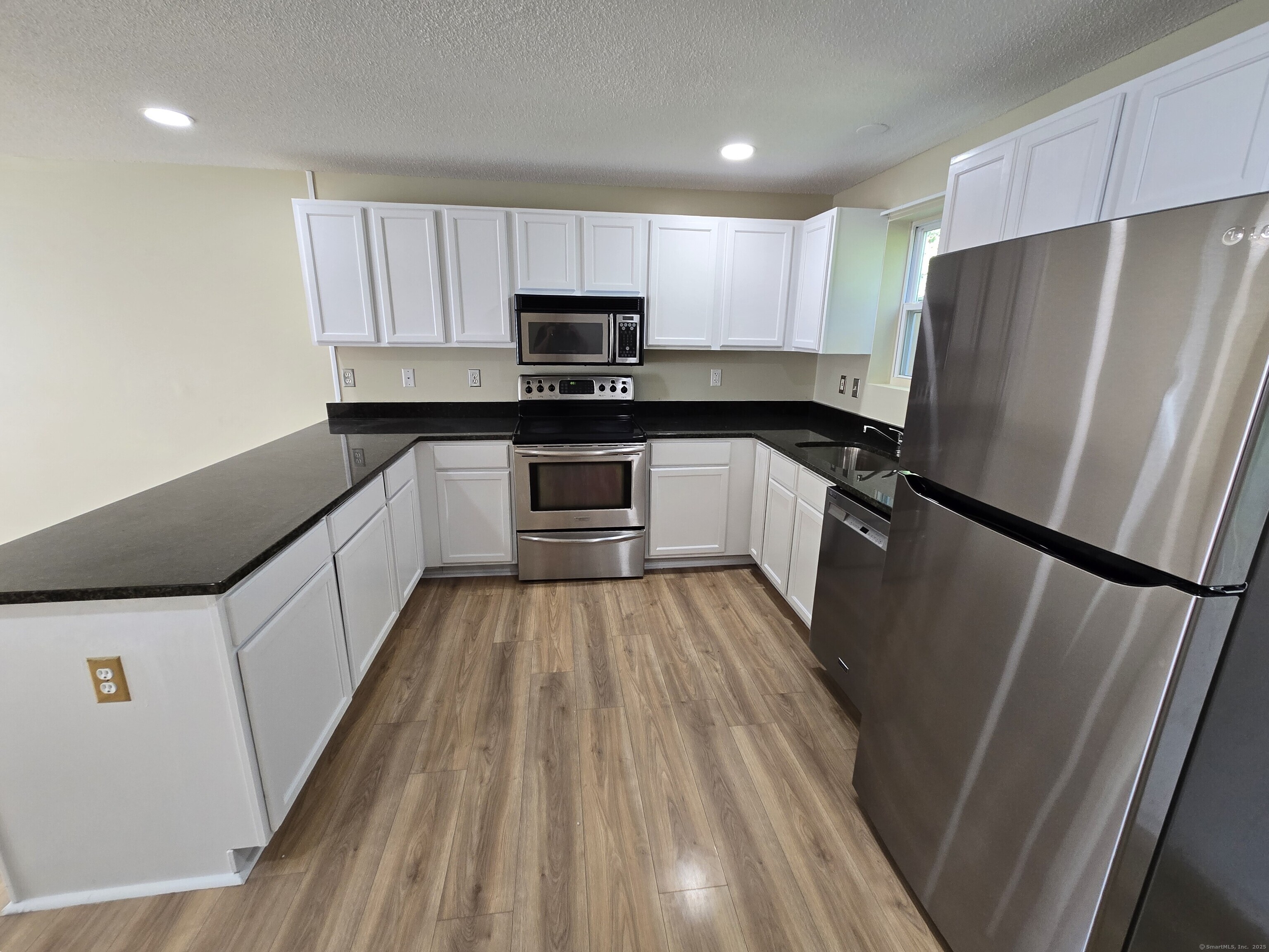 5 Periwinkle Lane, Unit 5 Glastonbury, CT 06033 - Photo 10 of 23 a kitchen with a refrigerator a sink and cabinets