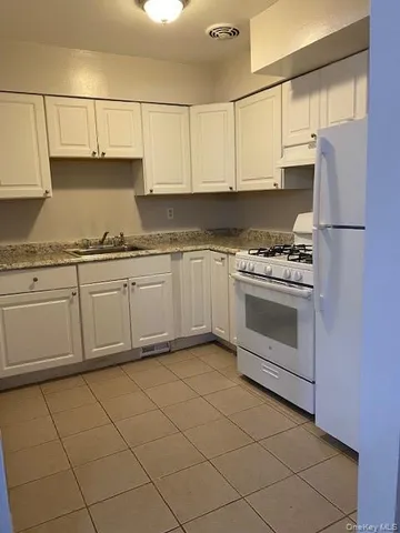 a kitchen with granite countertop cabinets stainless steel appliances and a sink