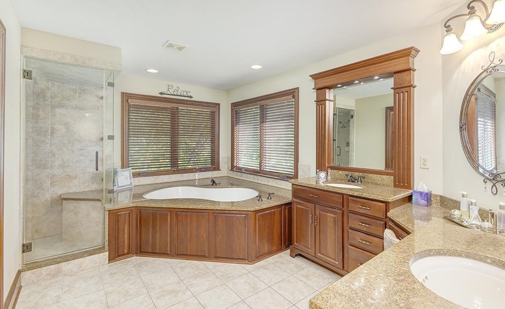 7417 Winding Way Roscoe, IL 61073 - Photo 18 of 40 a spacious bathroom with a tub sink and mirror