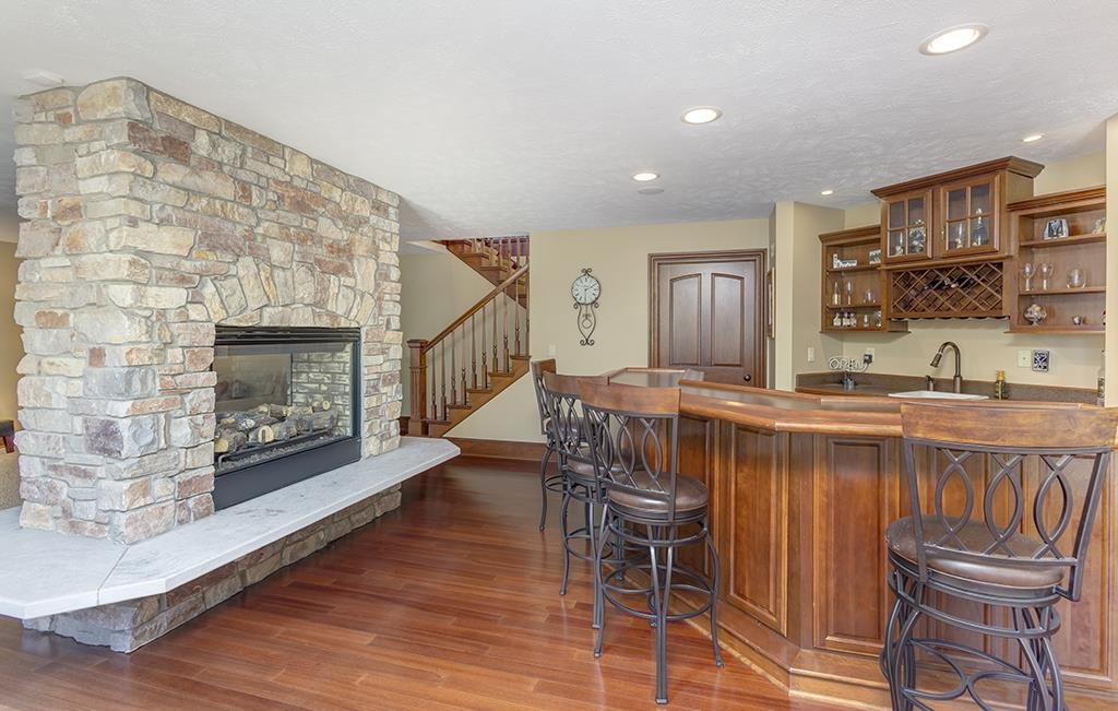 7417 Winding Way Roscoe, IL 61073 - Photo 24 of 40 a living room with furniture a fireplace and a flat screen tv