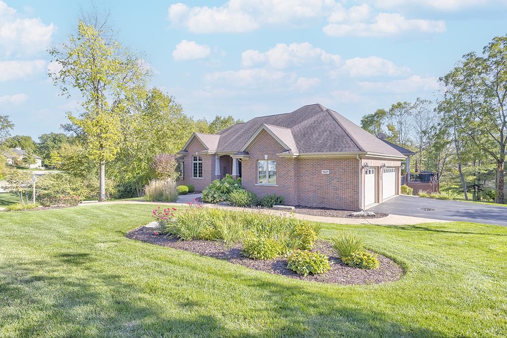 7417 Winding Way Roscoe, IL 61073 - Photo 40 of 40 a front view of a house with a big yard and potted plants