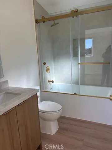 a bathroom with a granite countertop sink toilet and shower