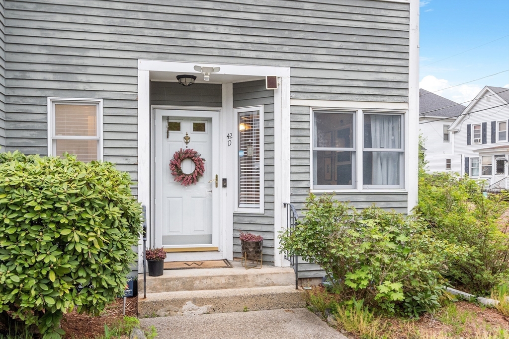 42 Farmland Road, Unit D Lowell, MA 01850 - Photo 1 of 26 a front view of a house with potted plants