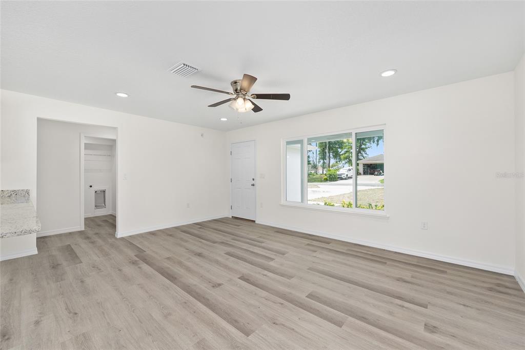 13019 Northeast 7th Loop Silver Springs, FL 34488 - Photo 11 of 35 an empty room with wooden floor and windows