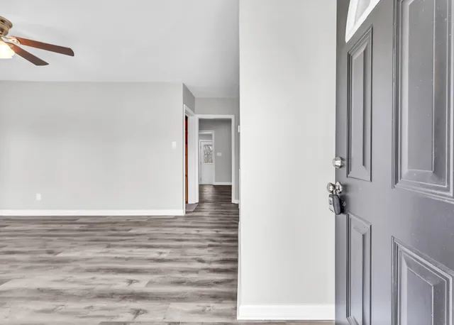 a view of a hallway with wooden floor and entryway