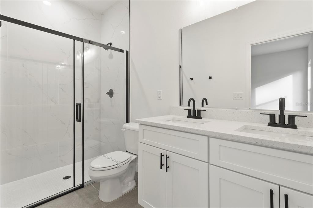 5534 Southwest 152nd Lane Road Ocala, FL 34473 - Photo 15 of 19 a bathroom with a sink a mirror a toilet and shower