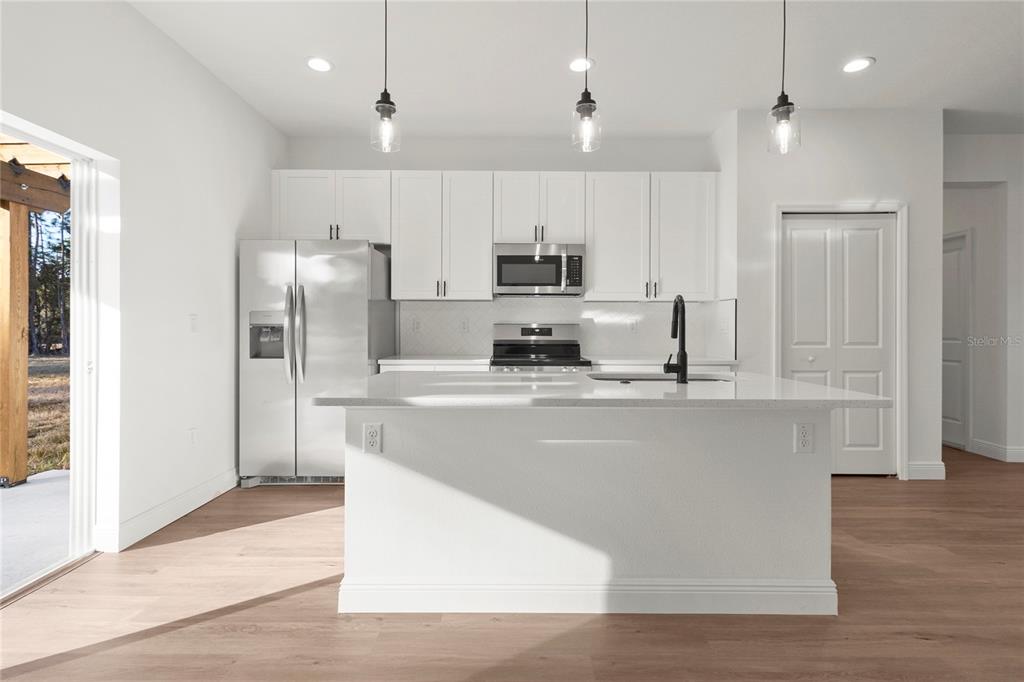 5534 Southwest 152nd Lane Road Ocala, FL 34473 - Photo 4 of 19 a kitchen with stainless steel appliances granite countertop a refrigerator a sink a stove and a refrigerator