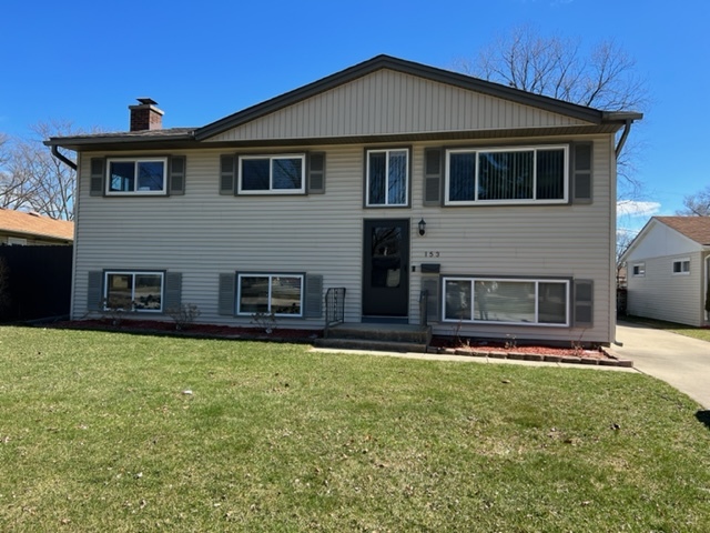 153 Fletcher Drive Wheeling, IL 60090 - Photo 2 of 22 a front view of a house with a yard
