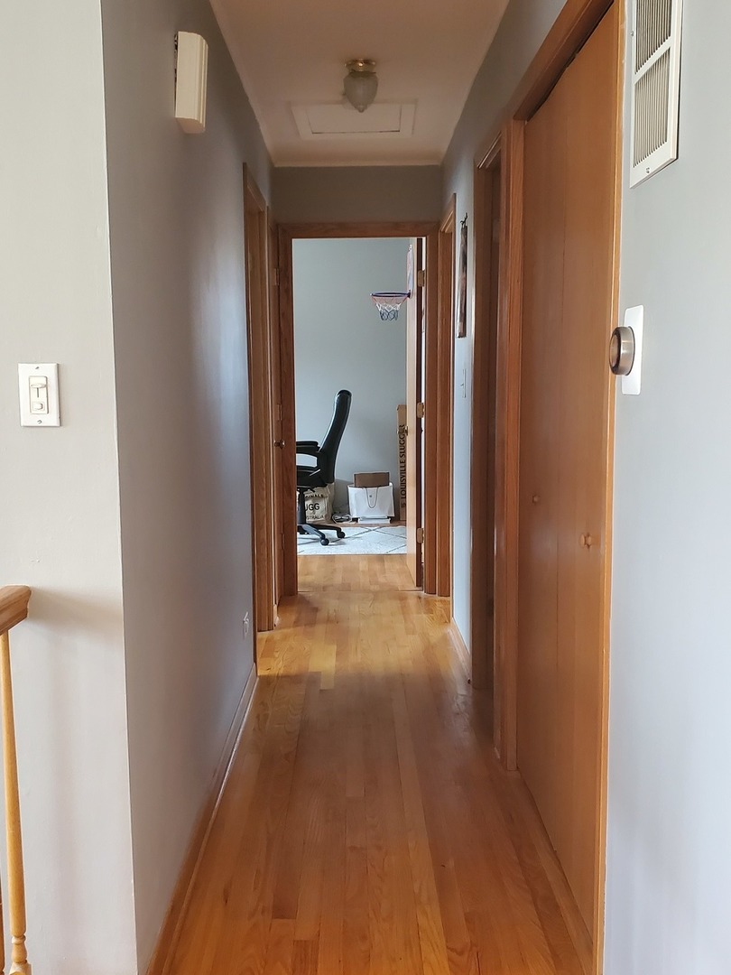 153 Fletcher Drive Wheeling, IL 60090 - Photo 6 of 22 a view of a hallway with wooden floor and a living room