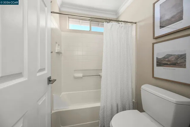 a white toilet sitting next to a bath tub shower