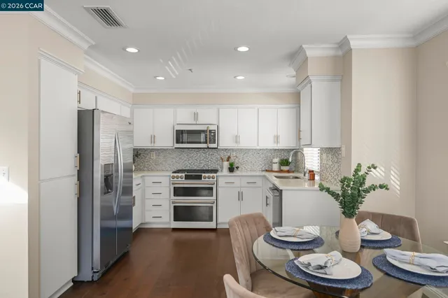a kitchen with a refrigerator and a white cabinets