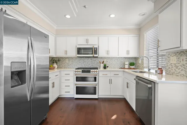 a kitchen with cabinets stainless steel appliances and a sink