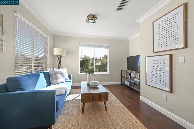a living room with furniture wooden floor and a large window