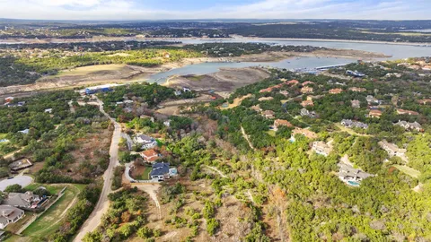 an aerial view of residential houses with outdoor space and trees