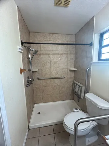 a white toilet sitting next to a bath tub and shower