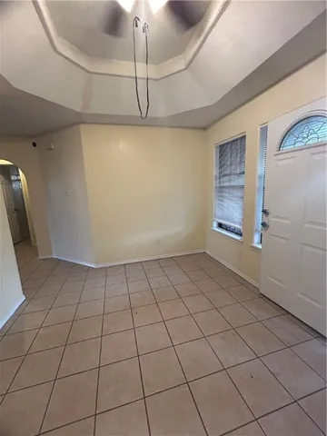 a view of an empty room and chandelier fan