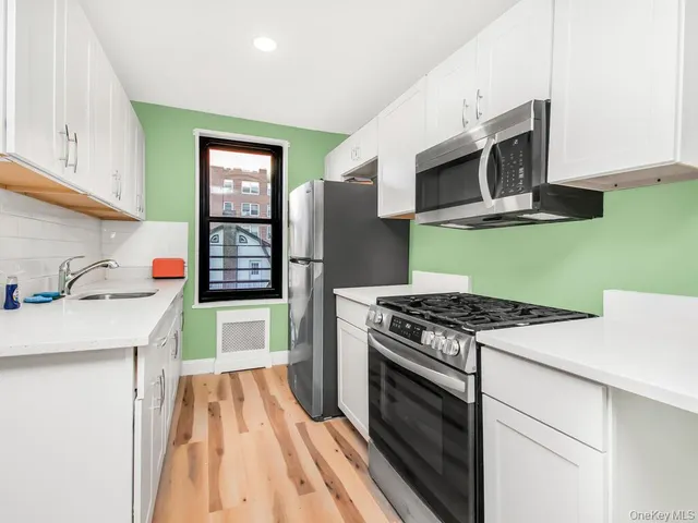 a kitchen with stainless steel appliances granite countertop a stove microwave and sink