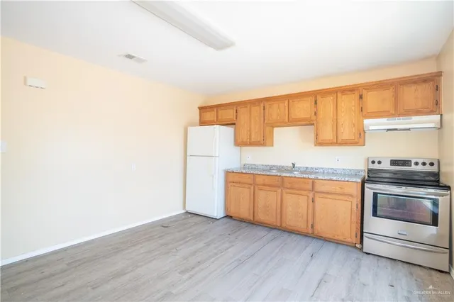 a kitchen with granite countertop wooden floors and stainless steel appliances