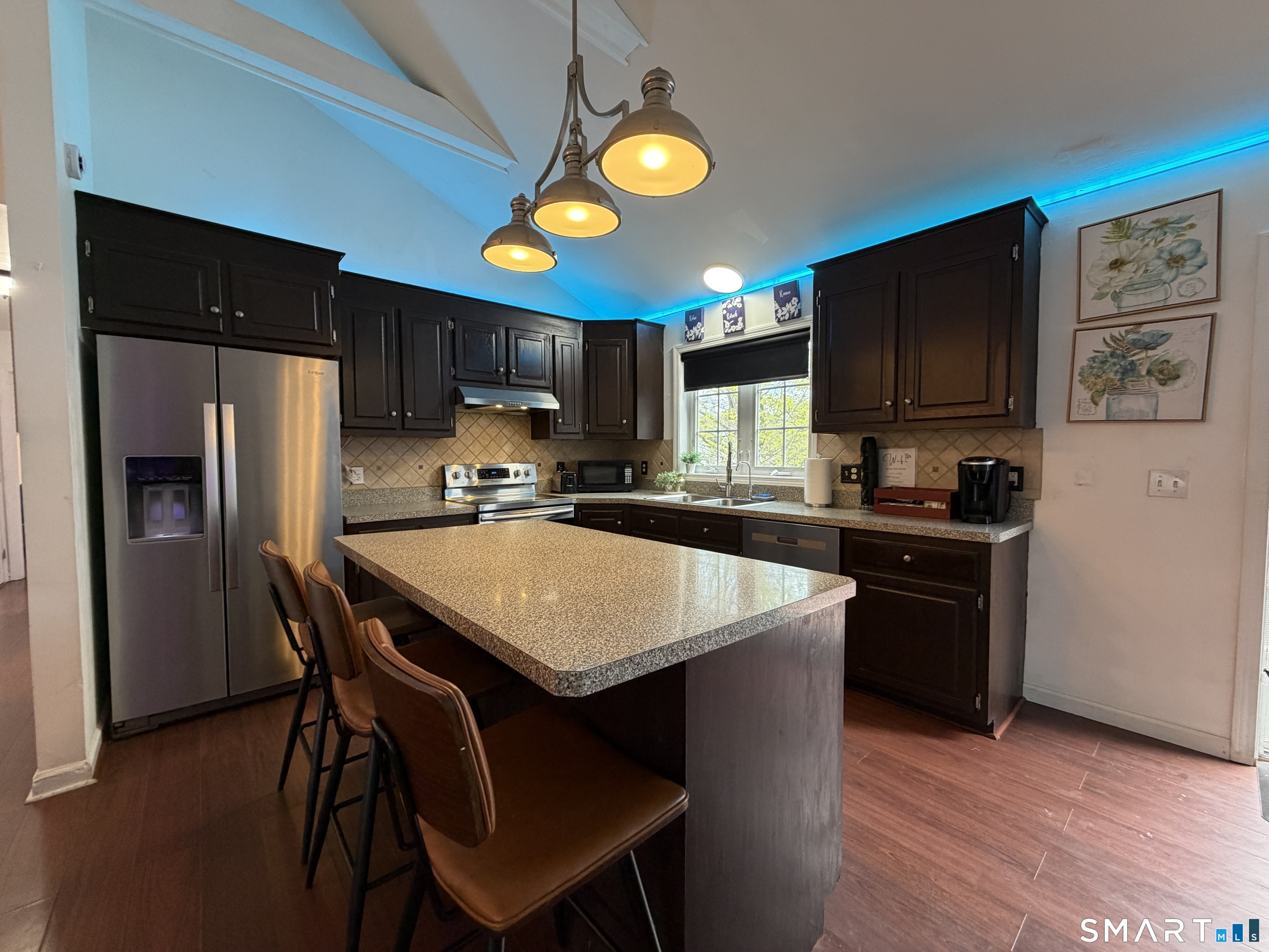 24 Quarry Street Norwich, CT 06360 - Photo 6 of 20 a kitchen with stainless steel appliances granite countertop a stove a refrigerator a sink a stove a dining table and chairs with wooden floor