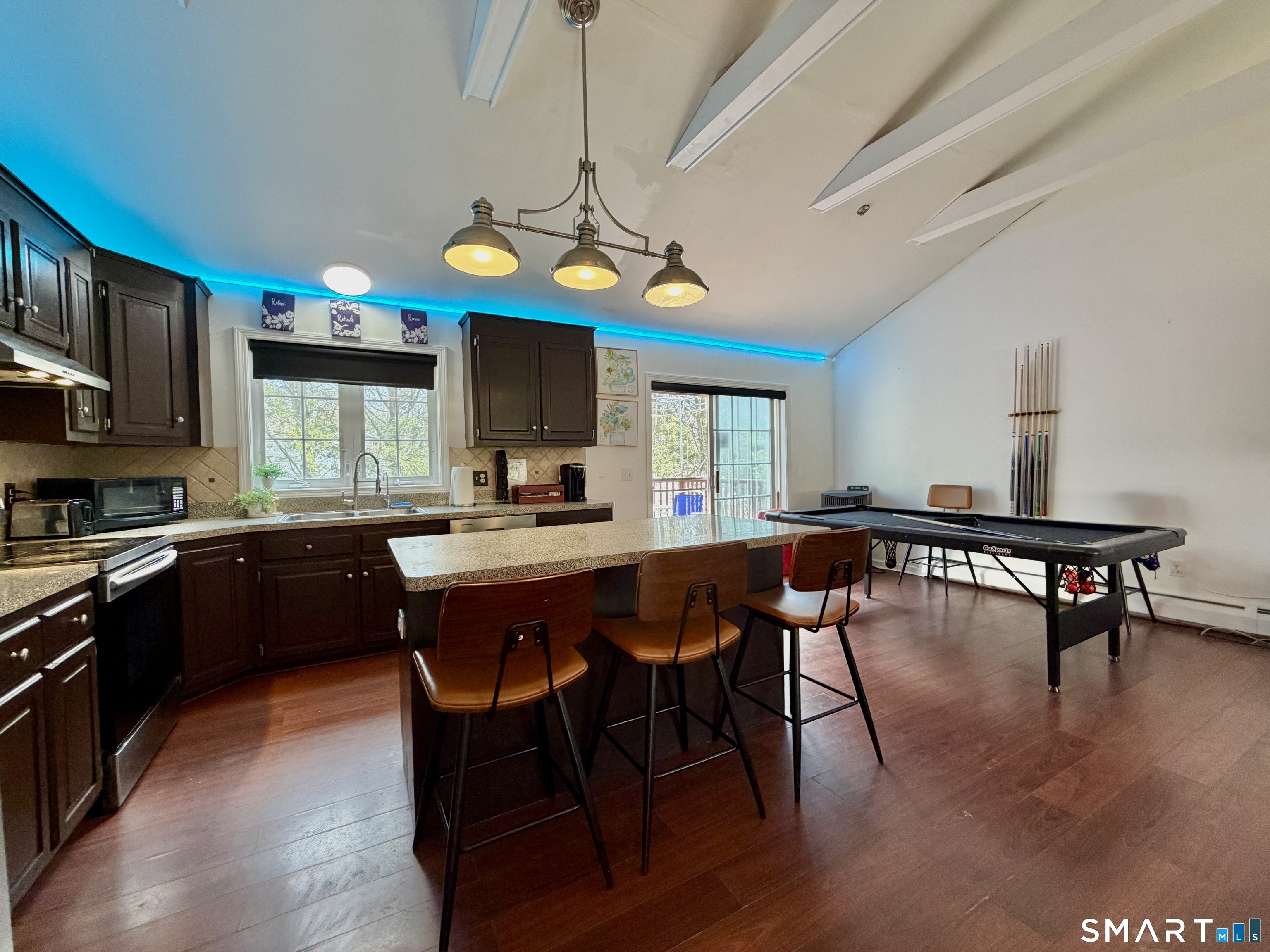 24 Quarry Street Norwich, CT 06360 - Photo 9 of 20 a kitchen with stainless steel appliances granite countertop a stove a refrigerator a kitchen island a dining table and chairs with wooden floor