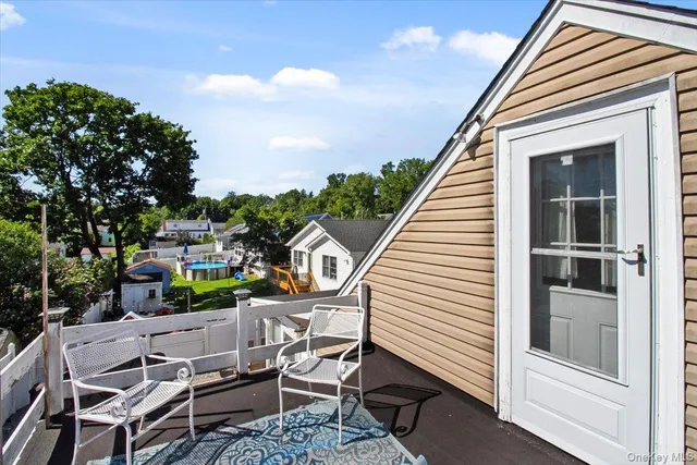 a view of a patio with table and chairs with wooden floor and fence
