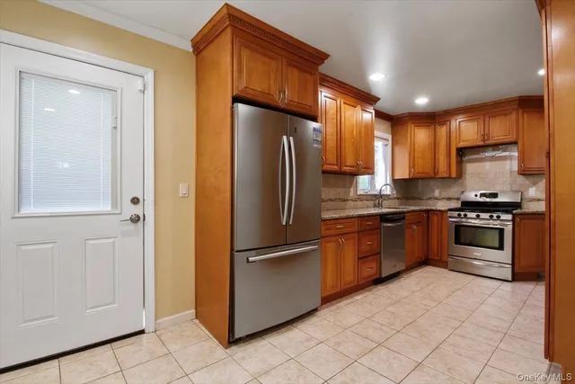 a kitchen with granite countertop a refrigerator and a stove top oven