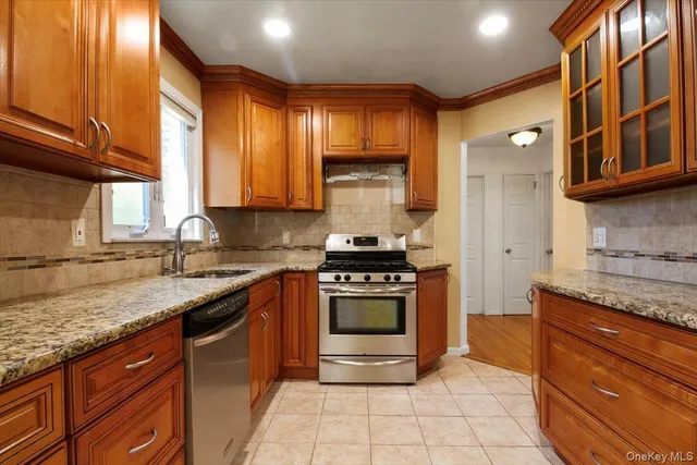 a kitchen with stainless steel appliances granite countertop a stove a sink and a microwave
