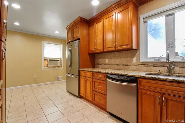 a kitchen with stainless steel appliances granite countertop a stove a sink and a microwave