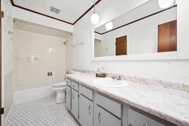 a bathroom with a granite countertop sink a toilet and shower