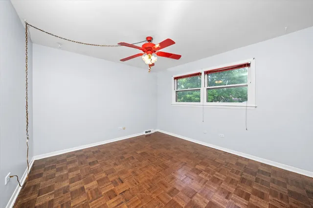 an empty room with a window and a fan