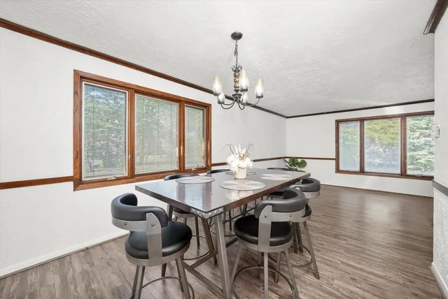 a view of a dining room with furniture wooden floor and chandelier