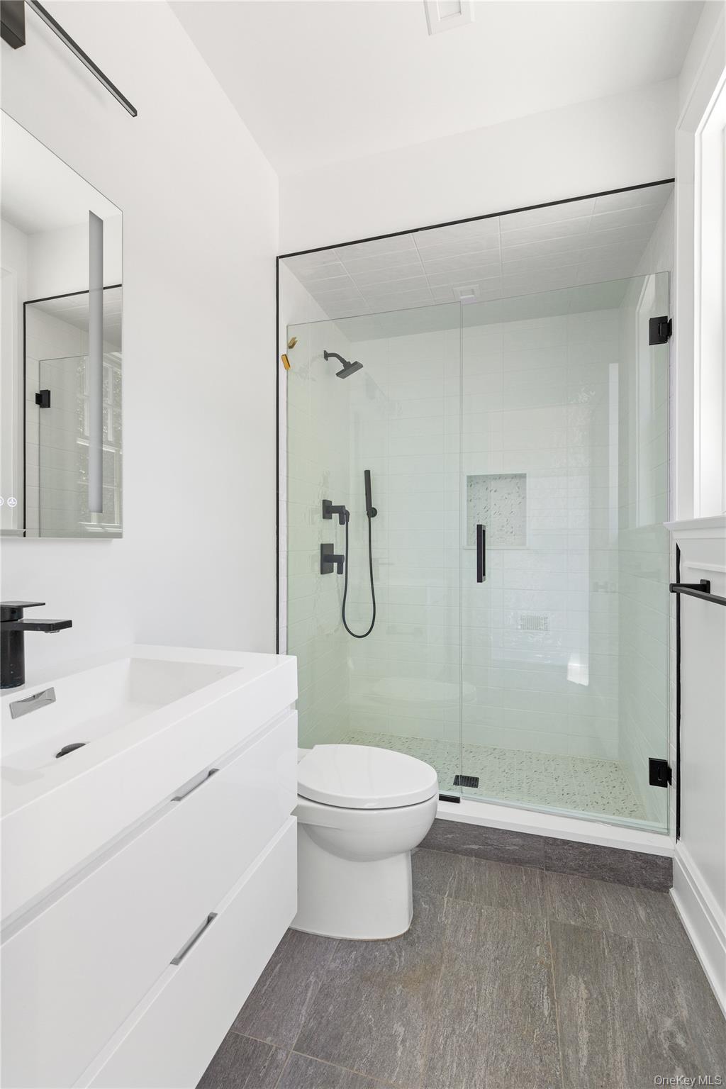 42 Mamaroneck Road Scarsdale, NY 10583 - Photo 28 of 47 A stylish full bath serves the pool, mudroom, and main living areas with contemporary finishes and an oversized glass-enclosed shower.