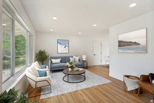 62 South Clark Lane Elk Ridge, UT 84651 - Photo 2 of 30 Spacious living area featuring expansive windows, LVP flooring, recessed lighting, and a neutral color palette
